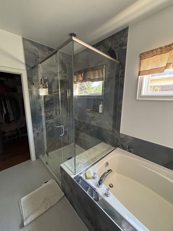 Full bath remodel with moody marble walls, walk-in shower, and bathtub