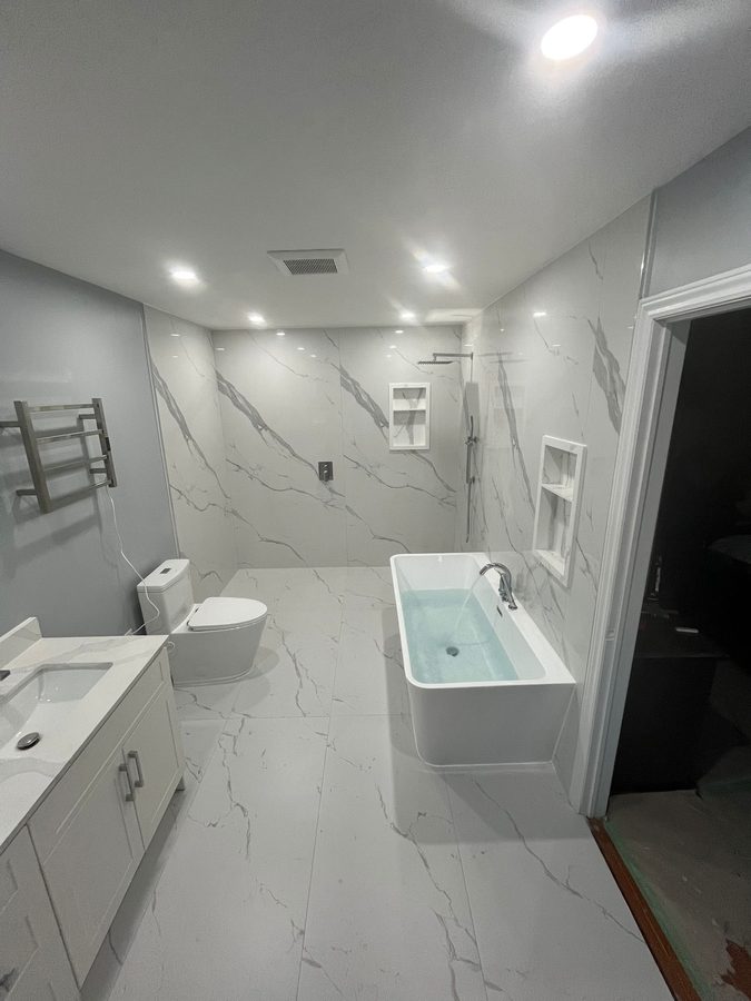 Full master bath remodel with Calacatta marble walls, freestanding soaker tub, and frameless walk-in shower